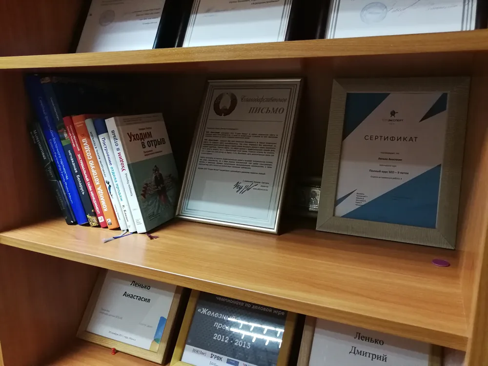 Сертификаты Дмитрия Ленько на книжной полке